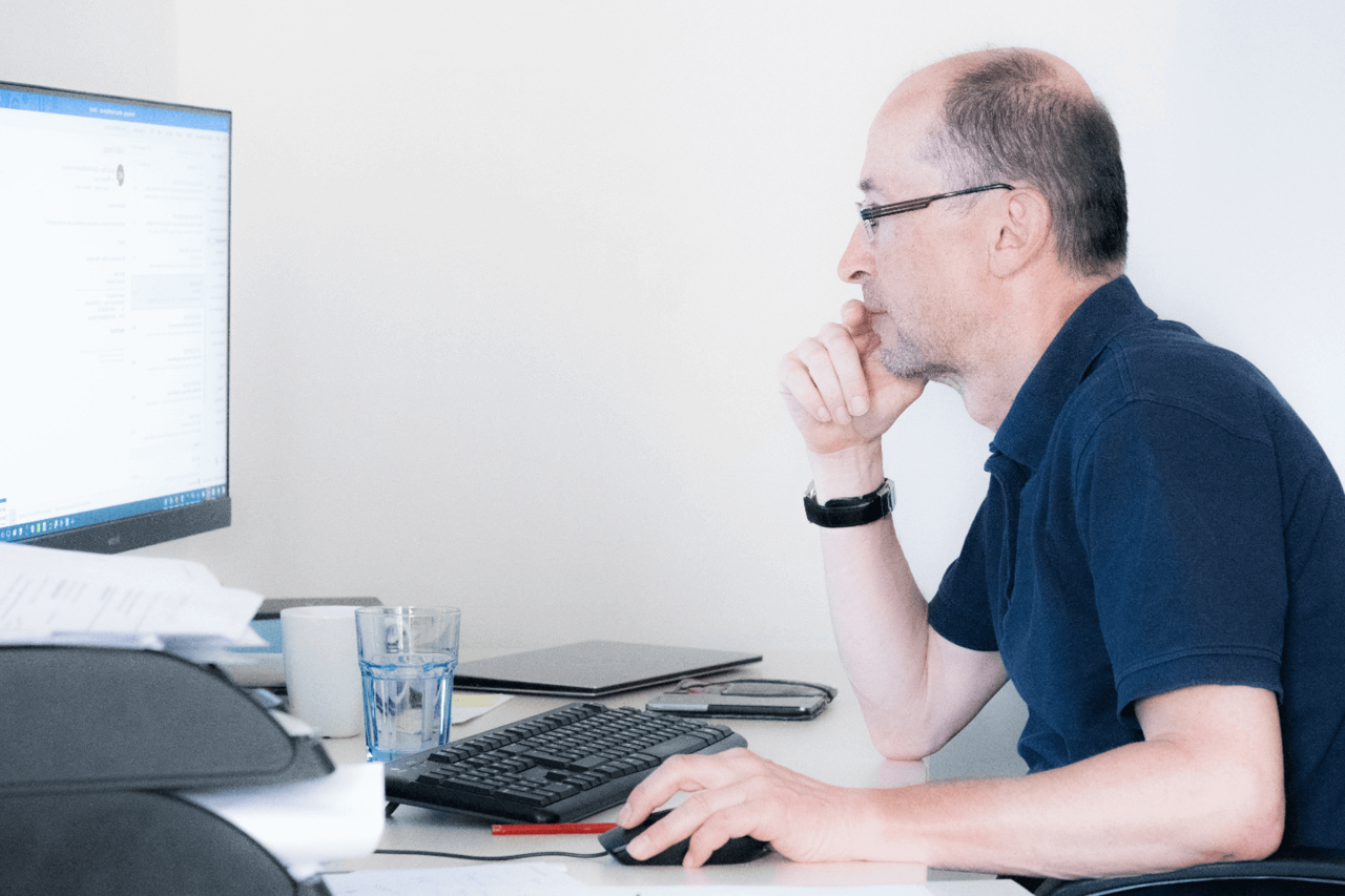 IT-Techniker prüft konzentriert Systeme am Monitor